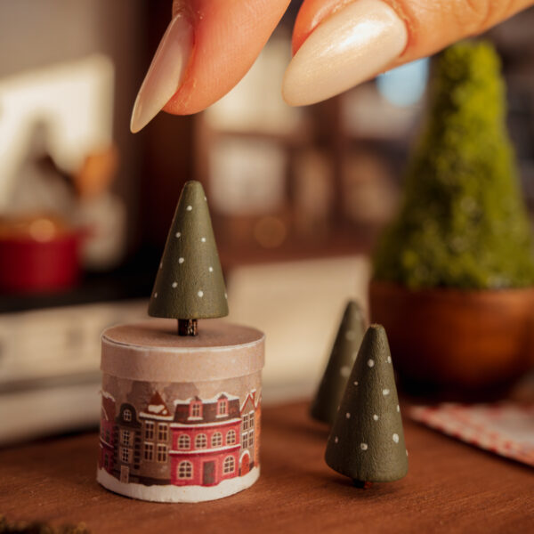 Abetos de madera en miniatura pintados en verde con pequeños lunares blancos.